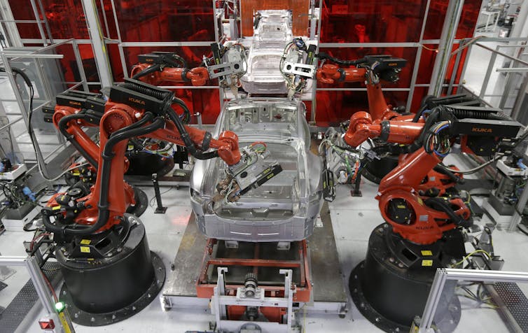 Robots assemble a car on a production line