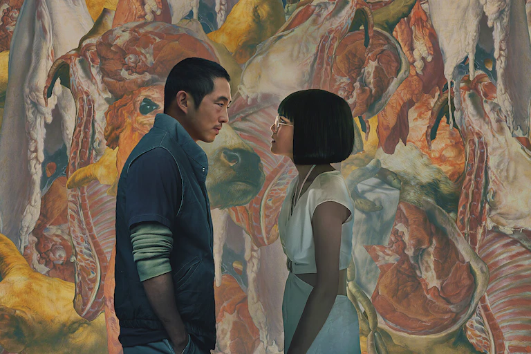 A man and a woman stare at each other in front of a graphic painting