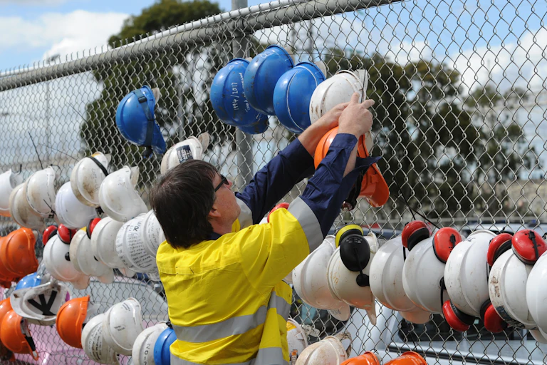 coal worker hangs hat on fence