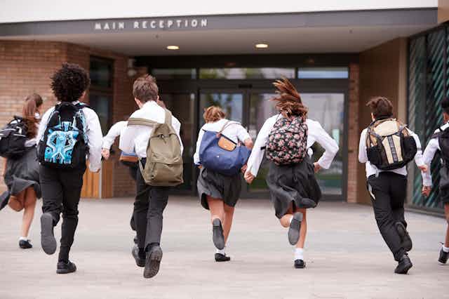 Schoolchildren running towards school building