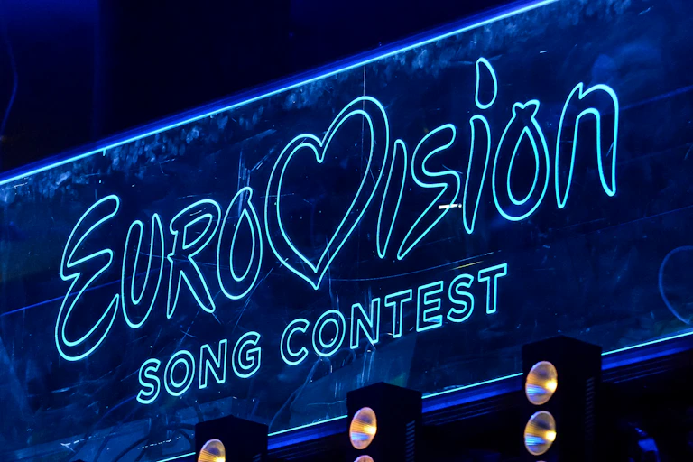 Blue neon lights spell the words 'Eurovision Song Contest'.