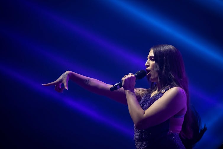 ماي مولر في صورة شخصية ، تمد يدها وهي تغني.