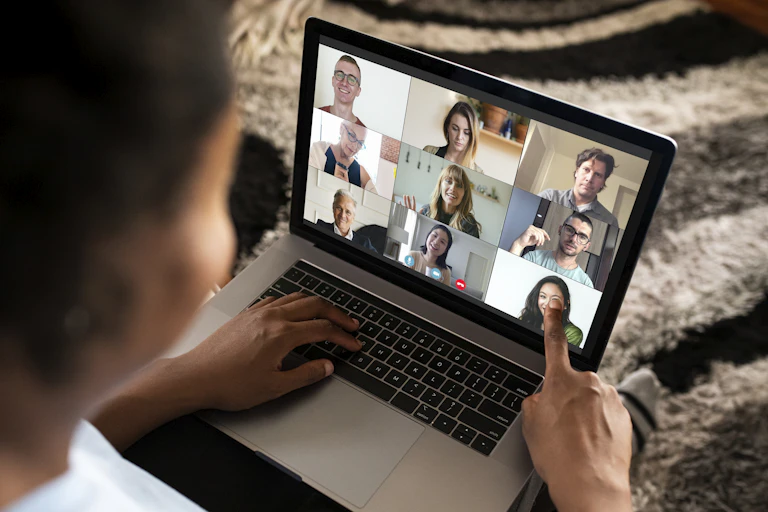 A person seen on a videoconference, looking at other participants' faces.