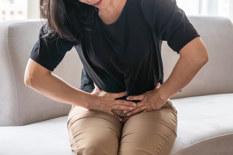 Woman holds per pelvis, in pain