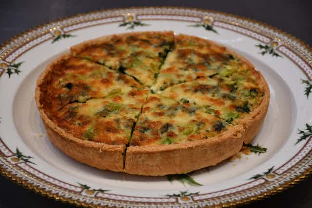 Coronation Quiche sliced into 6 portions on china plate