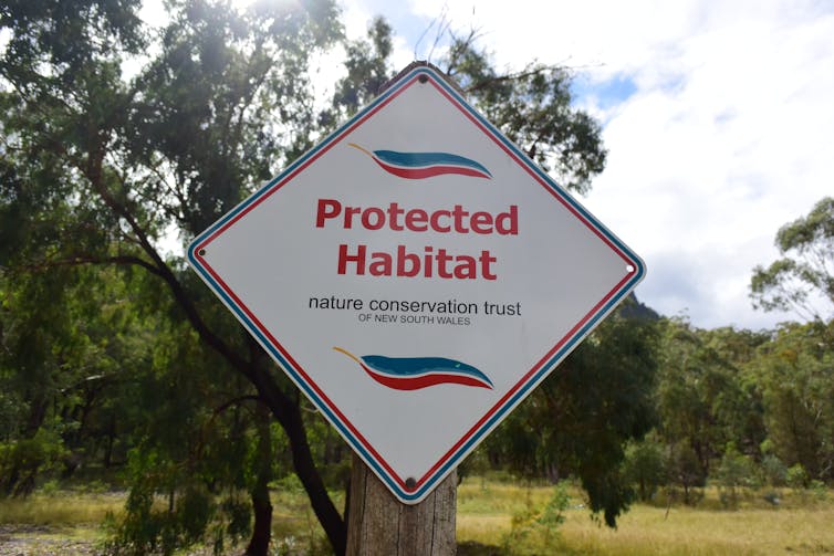 Sign reading 'Protected habitat', with trees in background