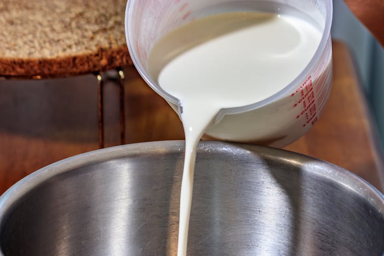 Pouring jug of cream into mixing bowl