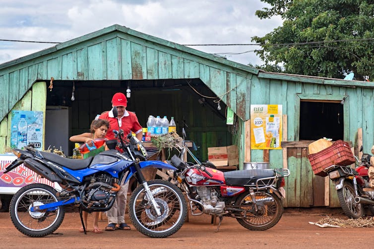 Motorbikes parked in front of a remote fuel station in South America.