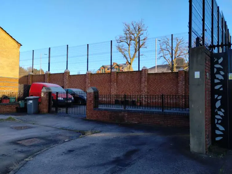 A brick-based fence barrier on a street.