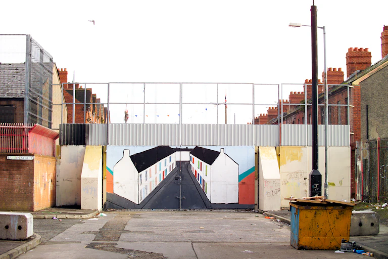 A mural painted on a barrier across a street.