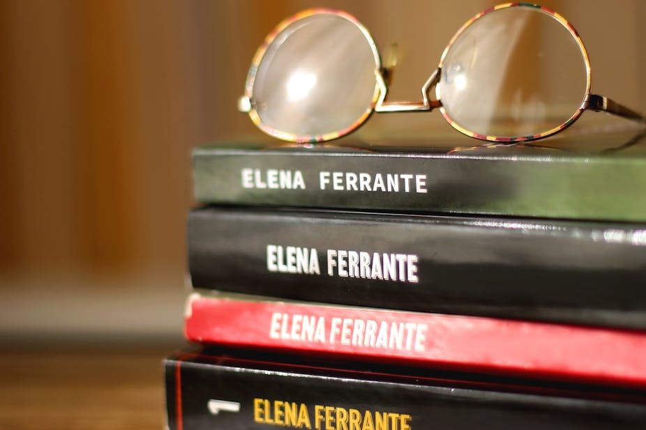 A stack of books by Elena Ferrante with a pair of glasses resting on top.