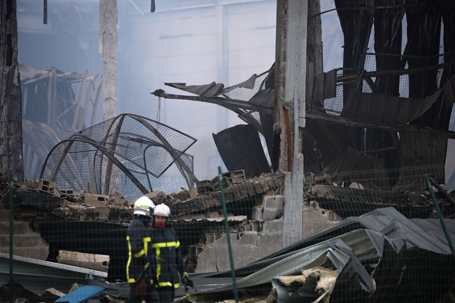 Des pompiers sur un site industriel détruit après un incendie
