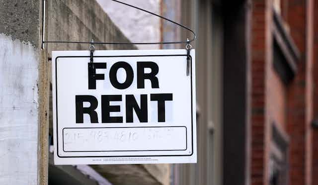 A hanging sign that says 'For Rent'
