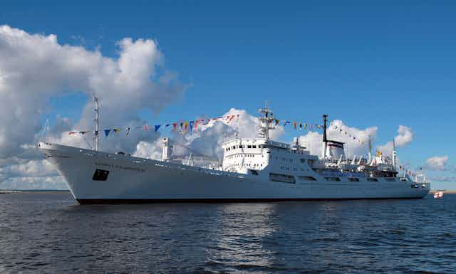 A ship at sea decorated with bunting.