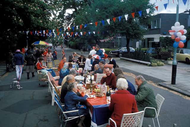 A view of a street party with red blue and white bunting.