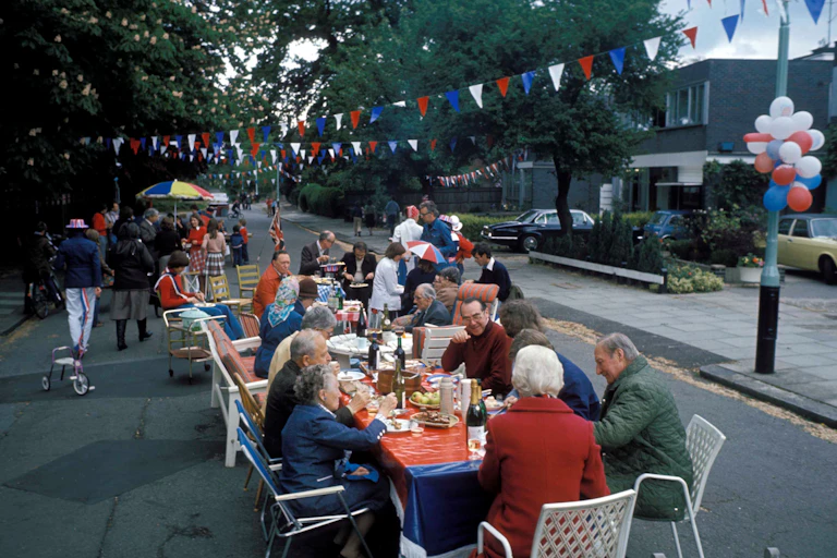 A view of a street party with red blue and white bunting.