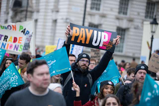 protester holds 'pay up' sign