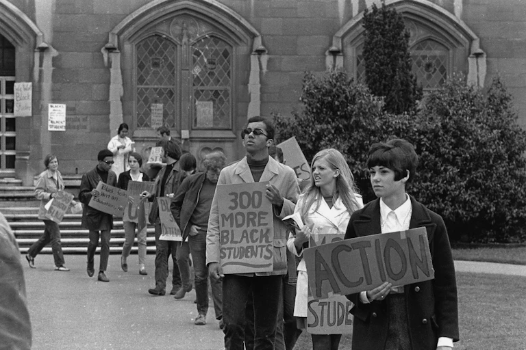 An historical photograph shows Black and white college students engaged in a 1960s civil rights protest.