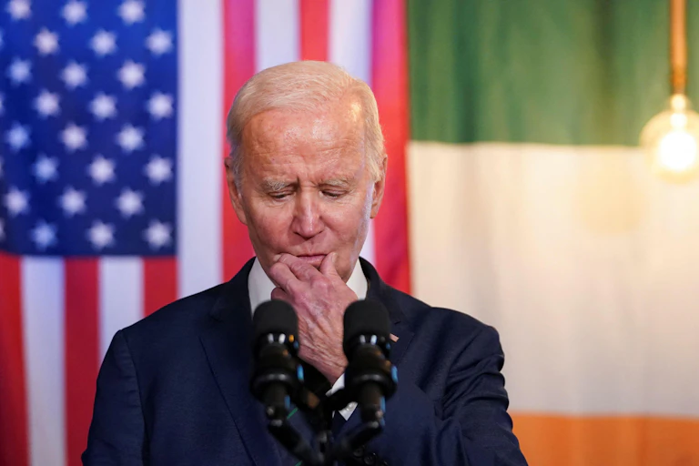 President Joe Biden in front of US and Irish flags.