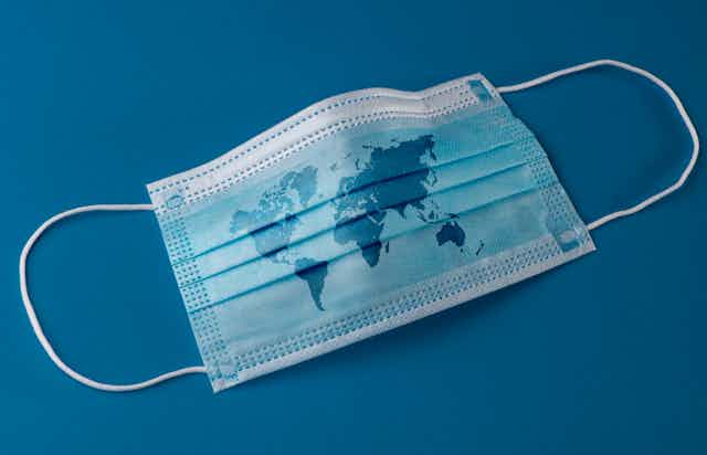 A blue surgical mask with a map of the globe on it