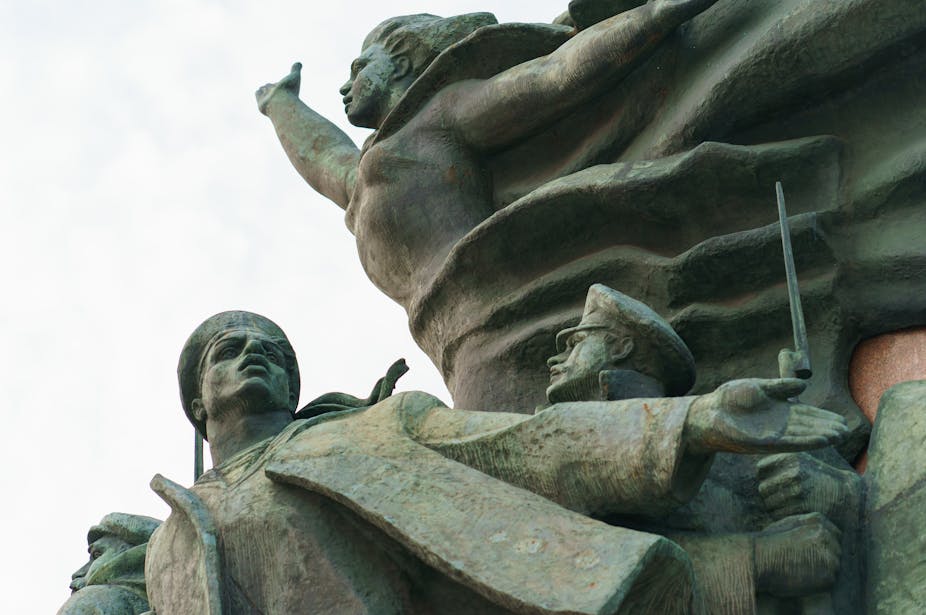 Détail d'un monument composé de plusieurs statues, où l'on voit notamment la statue d'une femme levant le bras
