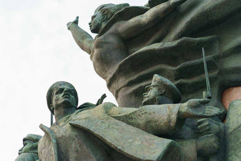 Détail d'un monument composé de plusieurs statues, où l'on voit notamment la statue d'une femme levant le bras