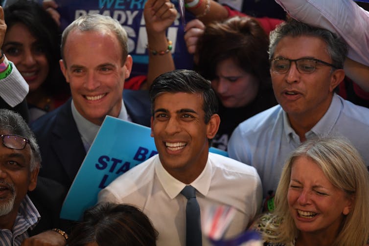 Dominic Raaband Rishi Sunal in the middle of a crowd of supporters.