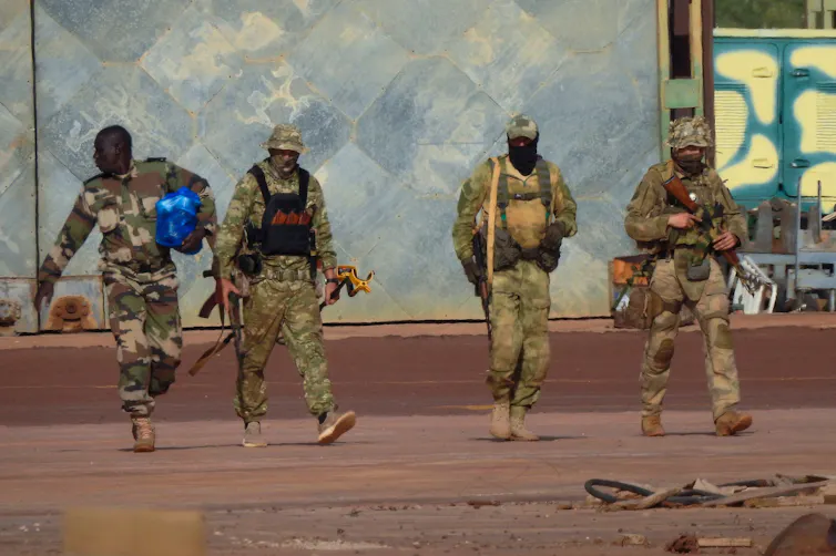 A a group of men in military uniform carrying weapons.