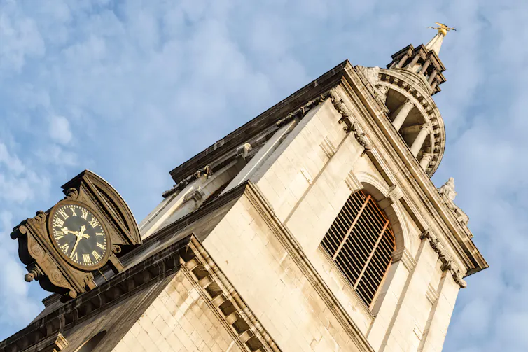 A church tower and clock seen against a blue sky.