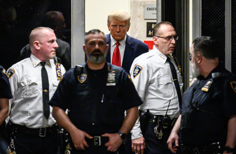 Donald Trump entouré de plusieurs policiers en tenue