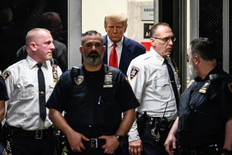Donald Trump entouré de plusieurs policiers en tenue