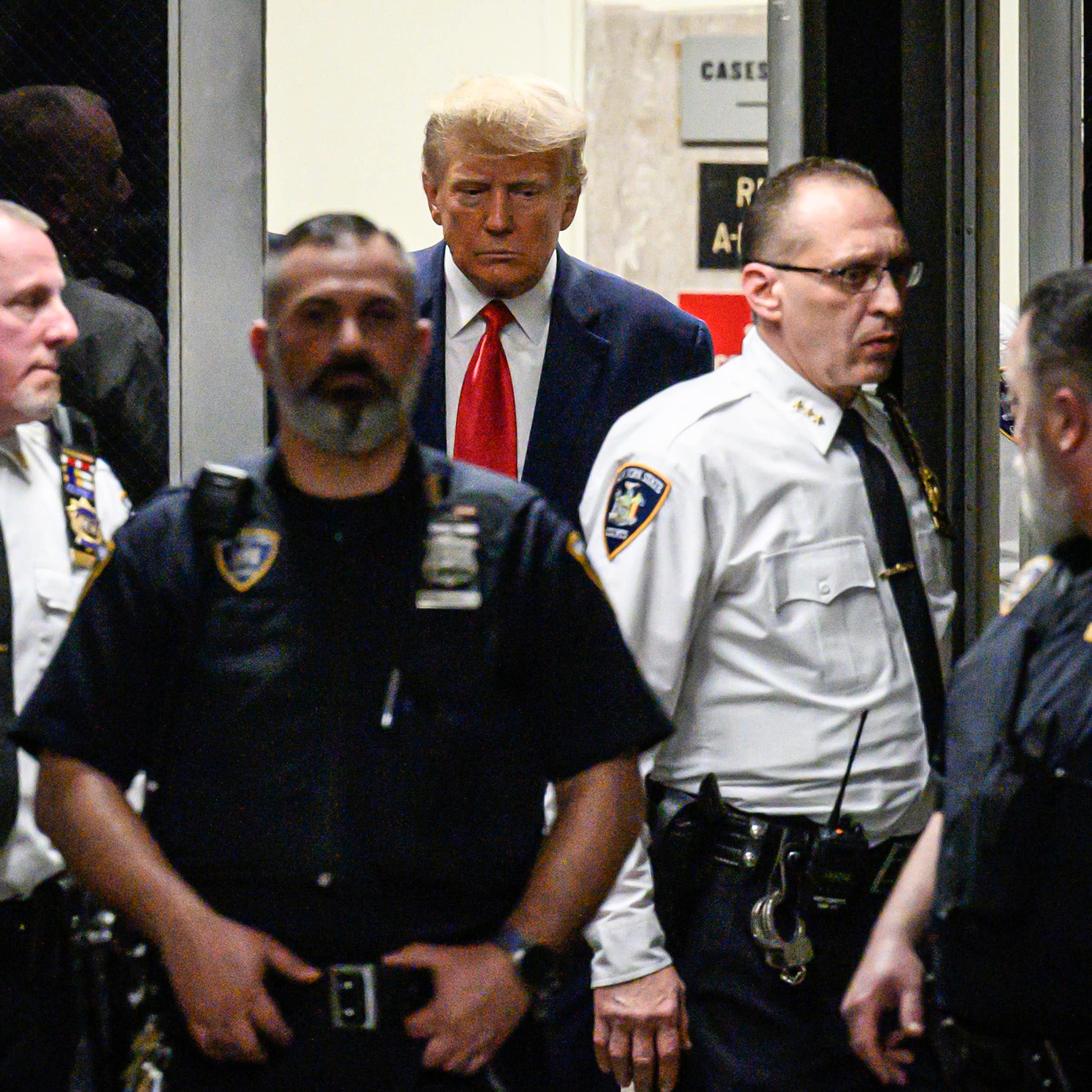 Donald Trump entouré de plusieurs policiers en tenue