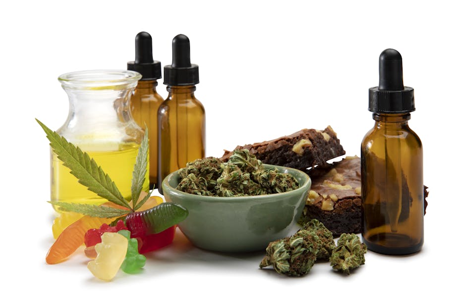 A display of cannabis gummies, brownies, and various cannabis products in bowls, jars, and bottles.