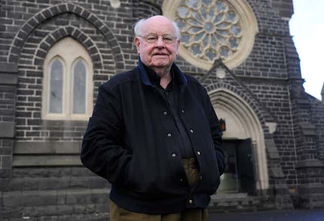 Father Bob in front of a church