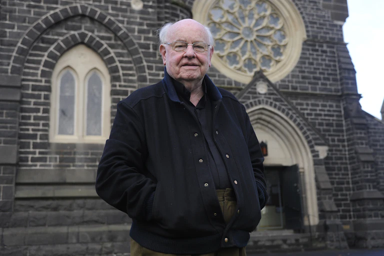 Father Bob in front of a church