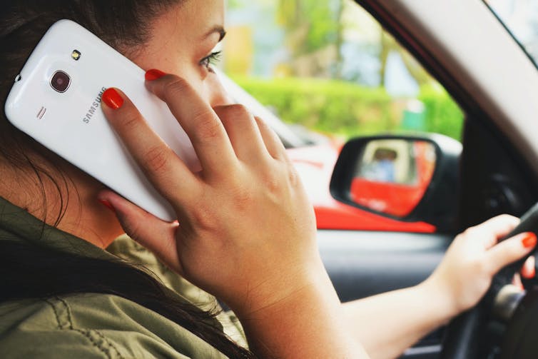 Woman on phone driving a car.
