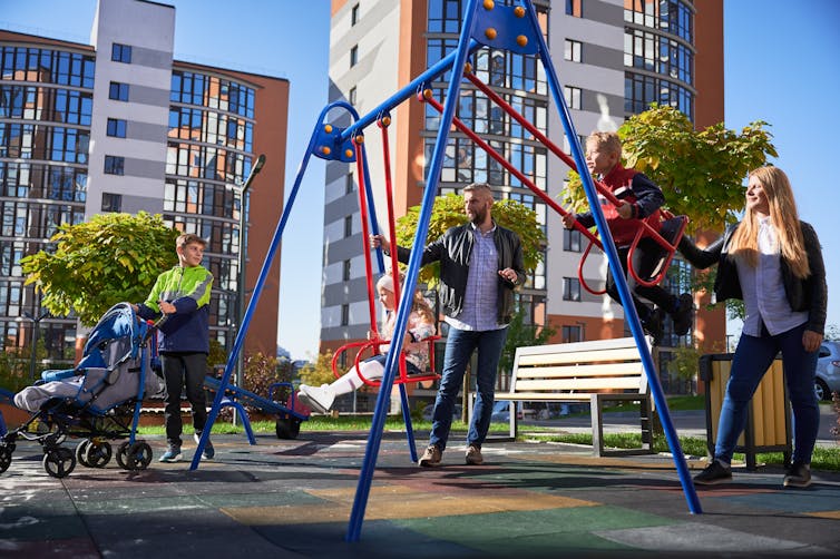 Families in a playground in front of high-rise apartments