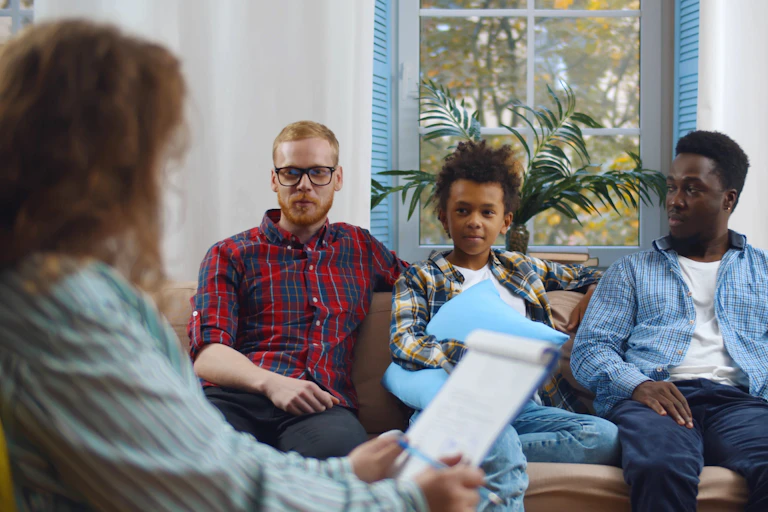 Couple with foster son consulting child protection services worker at home