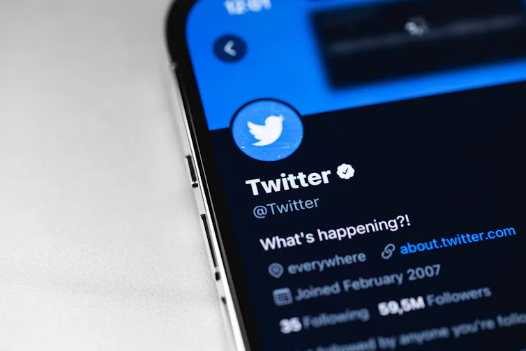 Close up photo of a mobile phone screen with Twitter's official Twitter account, with a verified tick mark