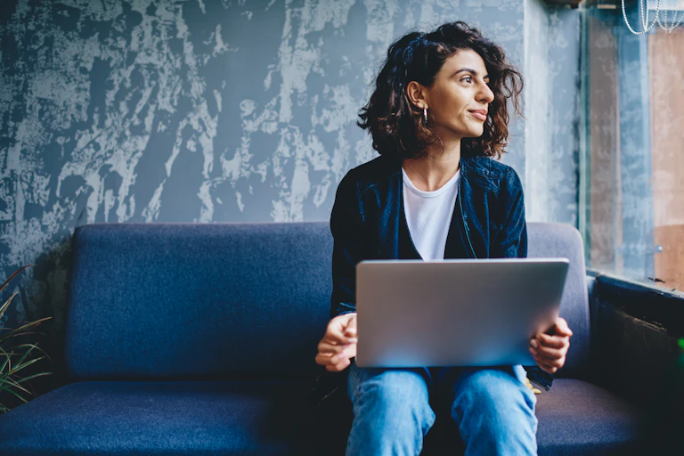 A young woman holding a laptop.