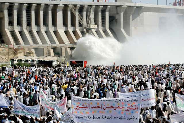 Hundreds of Sudanese holding banners praising and supporting their President Omar al-Bashir