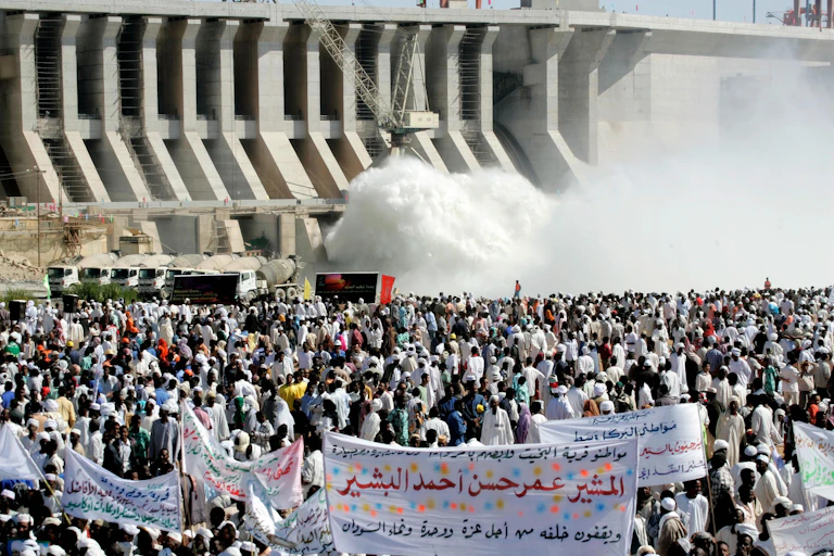 Hundreds of Sudanese holding banners praising and supporting their President Omar al-Bashir