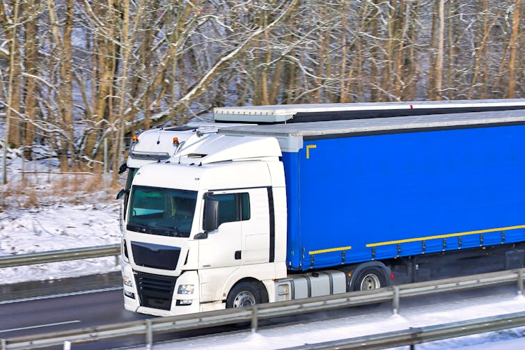 A lorry with white cabin and blue wagon.