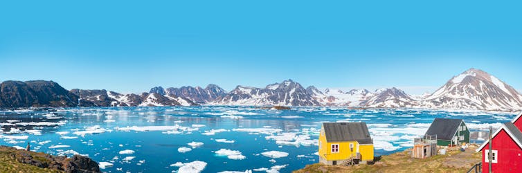 Wooden houses by a large bay filled with ice bergs