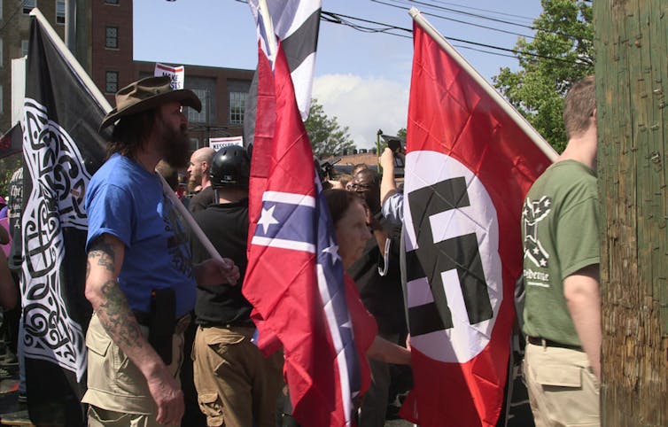 Marchers holding Nazi and Confederate flags.