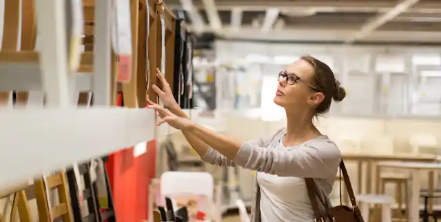 Shopper looking at chairs in furniture store.
