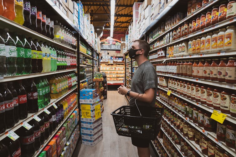 Man looks at sugary drinks at the supermarket