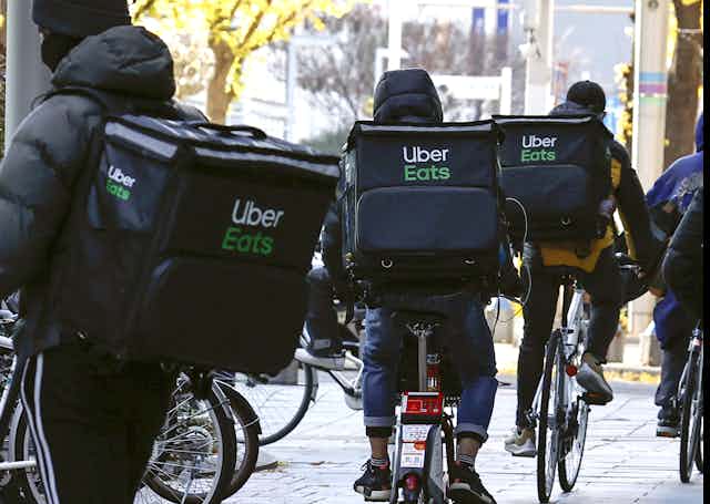 Bicycle riders with Uber Eats backpacks