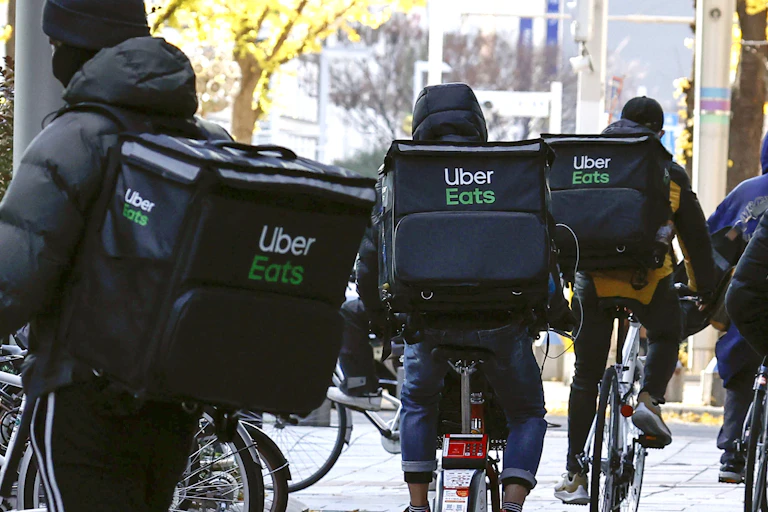 Bicycle riders with Uber Eats backpacks