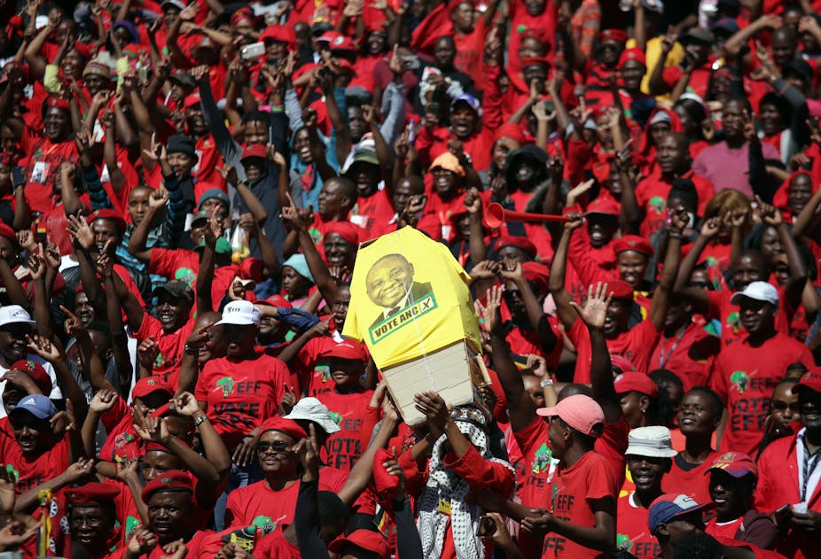 Supporters of the opposition EFF carry a mock coffin bearing the face of the President Cyril Ramaphosa, leader of the ruling ANC. 
